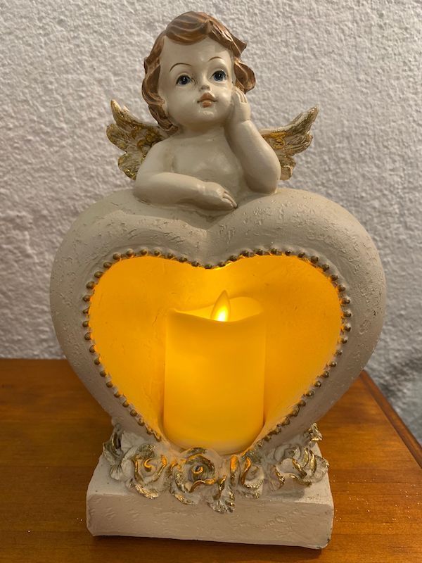 Figura de ángel con corazón y vela